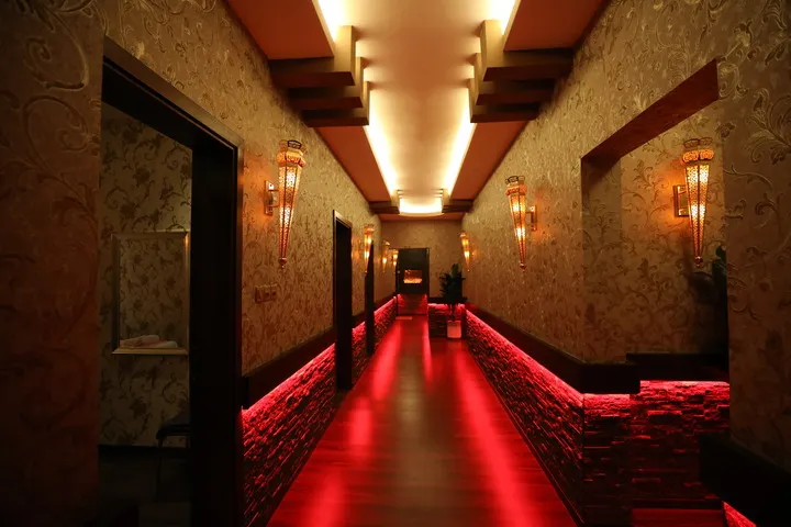 Softly lit corridor guiding guests toward the treatment rooms at Chandrima Spa Ajman